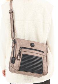 Borsa a tracolla in morbido ecopelle taupe con un accento rigato nero. Presenta una tasca con zip e una tracolla regolabile. Dettaglio della superficie testurizzata.