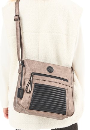 Crossbody bag in soft taupe faux leather with a black ribbed accent. Features a zip pocket and adjustable strap. Textured surface detail.