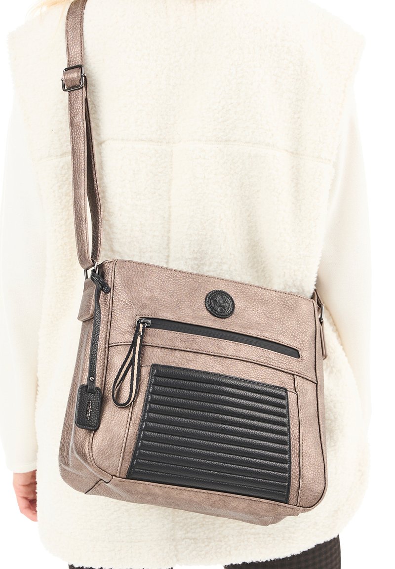 Borsa a tracolla in morbido ecopelle taupe con un accento rigato nero. Presenta una tasca con zip e una tracolla regolabile. Dettaglio della superficie testurizzata.