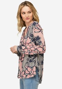 Langärmlige Bluse mit floralem Muster in Rosa und Navyblau, mit gespaltenem Saum und leichtem Stoff für eine entspannte Passform.