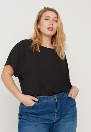 Schwarzes, locker sitzendes Oberteil mit rundem Ausschnitt, kurzen Ärmeln und glatter Textur, kombiniert mit blauen High-Waist-Jeans.