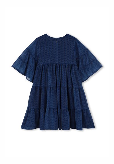 Robe bleu marine à volants avec manches courtes évasées, présentant un motif texturé de flèches. Fermeture au dos avec ouverture en forme de goutte, tissu doux.