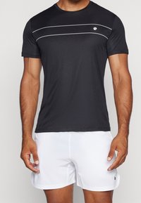 Camiseta atlética negra de manga corta, con tejido texturizado, rayas horizontales blancas y un pequeño logo en el pecho.