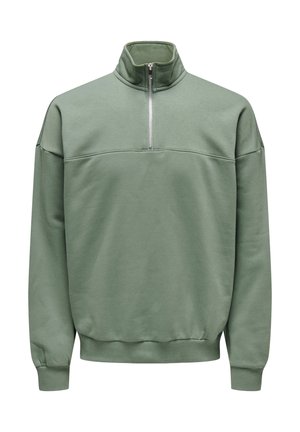 Green pullover with a high collar, featuring a half zipper, soft fabric, and ribbed cuffs and hem. Plain design with a relaxed fit.