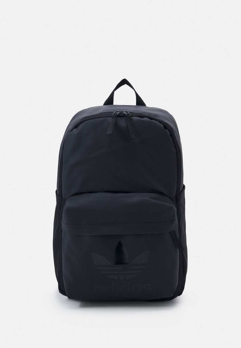 Sac à dos noir en nylon avec un design structuré, équipé d'une poche avant et d'un logo discret en relief sur la partie inférieure.