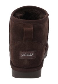 Donkerbruine suède enkellaarzen met een ronde neus, zachte voering en een klein treklipje aan de achterkant. Voorzien van een merklabel aan de zijkant.