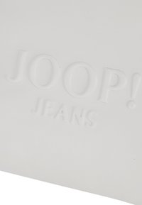 Biely vegánsky kožený púzdr sú s embosovaným logom "JOOP! JEANS", s hladkou textúrou a bez ďalších prídavných prvkov alebo akcentov.