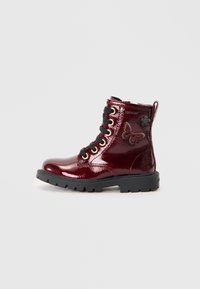 Bottines bordeaux brillantes avec des lacets noirs, des œillets dorés et un accent de papillon à motif sur le côté. Semelle noire épaisse.