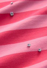 Roza prugasta tkanina koja se odlikuje teksturom mekanog pamuka s ugrađenim rhinestones za dodatne detalje i vizualni interes.