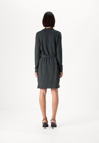Abito maglione grigio scuro con maniche lunghe, vita cintata e taglio dritto, realizzato in morbido tessuto texturizzato. Finito sopra il ginocchio.