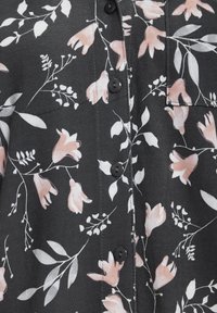 Bloemige overhemd met knopen, voorzien van een donkere achtergrond met roze en witte bloemen, zwarte knopen en een voorzakdetail. Gevoelige stof.