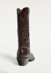 Braune Leder-Cowboy-Stiefel mit gestickten Details, spitzem Fuß und bescheidenem Blockabsatz. Verfügt über eine strukturierte Oberfläche und dekorative Muster.