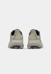 Light green athletic shoes with a textured fabric upper and cushioned sole, featuring a sleek design and contrasting gray accents.