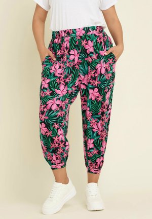 Floral print jogger pants featuring pink flowers and green leaves on a dark background, with an elastic waistband and side pockets.