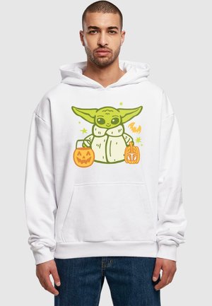 Felpa bianca con cappuccio che presenta un personaggio dei cartoni animati con la pelle verde e grandi orecchie, che tiene due secchi di caramelle arancioni a forma di zucca; vestibilità comoda, tasca frontale.