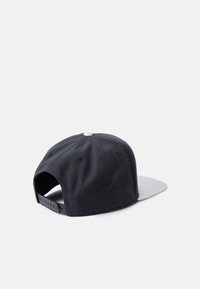 Czarna czapka baseballowa z materiału z szarym daszkiem, z płaskim daszkiem, regulowanym zapięciem na snapback oraz białym guzikiem na górze.
