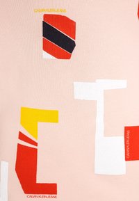 Calvin Klein Jeans Shirt aus pinkem Stoff mit abstrakten Formen in Rot, Schwarz, Gelb und Weiß. Auffälliges Logo-Detail in Gelb.