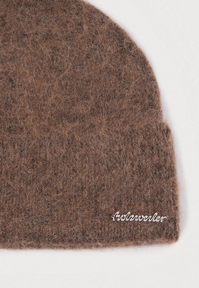 Hnedý vlnový čiapka s mäkkým, štruktúrovaným povrchom. Obsahuje prehnutý lem a malú striebornú značku vyšitou na boku.