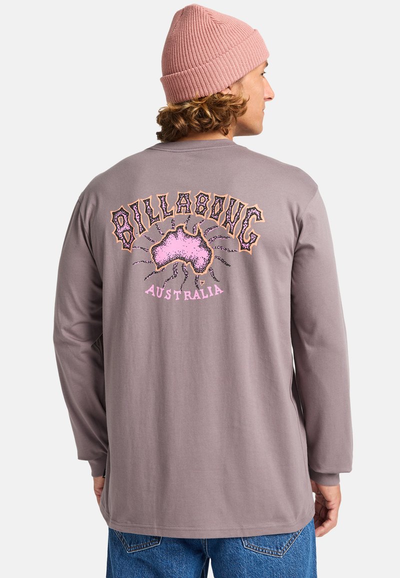 Szara koszula z długim rękawem z kolorową grafiką "Billabong Australia" oraz wzorem mapy Australii z tyłu. Wełniana czapka dodaje faktury.