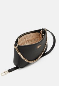 Musta synteettinen olkalaukku vetoketjullisella sululla, kultaketjunaulakolla ja beige sisäosalla, jossa on GUESS-brändäys. Rakenteeltaan teksturoitu ja kompakti muotoilu.