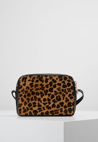 Crossbody taske med leopardmønster og blød, struktureret overflade; sorte accenter; rektangulær form; har lynlås og skulderrem.