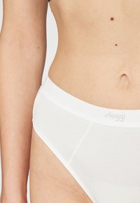 Witte katoenen briefs met een gladde textuur, elastische tailleband met de merknaam "sloggi," getailleerd ontwerp en schone lijnen.