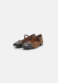 Zapatos planos de estampado de leopardo con puntera de cuero sintético negro, detalle de correa y acentos de tachuelas doradas en la parte superior. Diseño de tacón bajo.