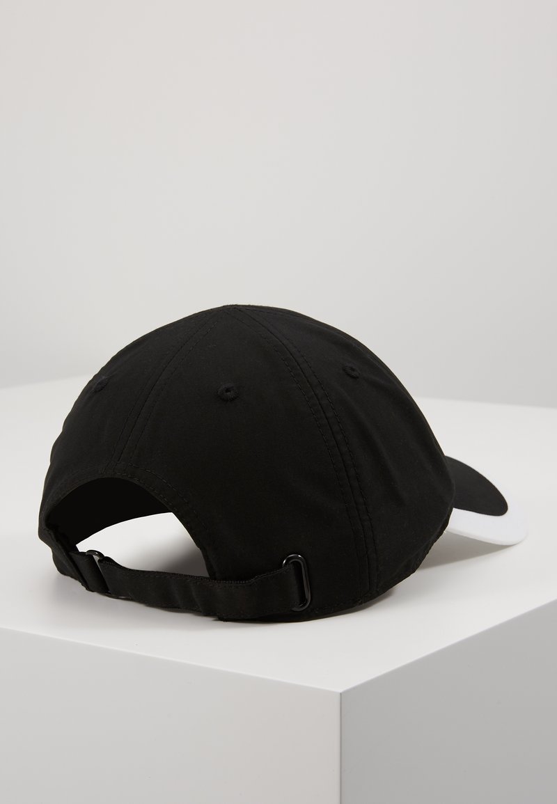 Gorra negra con visera blanca, hecha de tela, con una correa ajustable en la parte posterior y seis paneles cosidos para dar estructura.