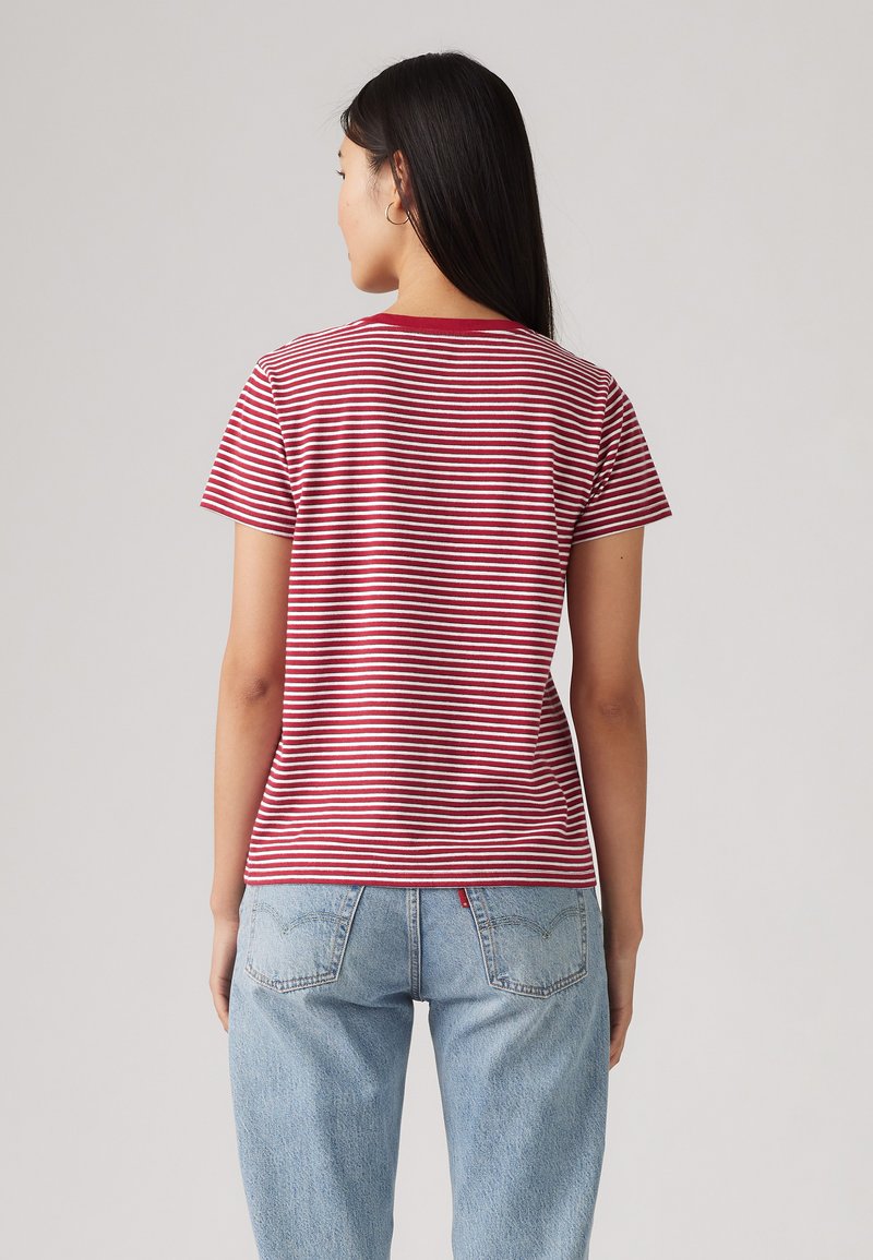 Camiseta de rayas rojas y blancas con mangas cortas, cuello redondo, corte casual, hecha de una tela ligera, combinada con jeans de color azul claro.