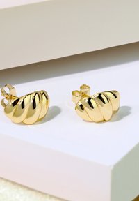Orecchini d'oro con un design torcigliato caratterizzato da una superficie lucida e tre sezioni curve. Comprendono un fermaglio a farfalla per una vestibilità sicura.