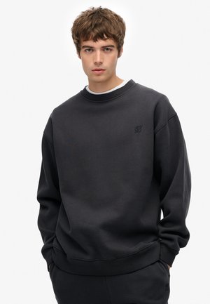 Sudadera gris oscuro con cuello redondo, puños y dobladillo acanalados. Presenta un logo en relieve en el pecho y tiene un ajuste relajado.