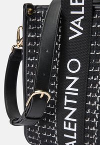 Črna pletena torba za ramo z teksturiranim dizajnom, usnjenimi detajli, zlatim okovjem in trakom s tiskom "VALENTINO".