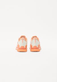 Lightweight athletic shoes with a pale gray upper, orange accents, textured surface, and distinct tread pattern on the sole.