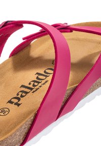 Pink leather sandal with a cork footbed, featuring two thin straps on top, and a white rubber sole. The logo "palado" is visible.