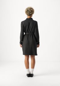 Σκοτεινό γκρι �φόρεμα με ζώνη, μακριά μανίκια, γιακά και μήκος μέχρι το γόνατο. Φτιαγμένο από μαλακό ύφασμα με λεία υφή.