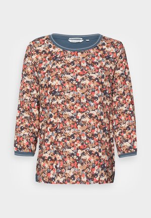 Camisa con estampado floral, de manga 3/4, escote redondo y puños en contraste. Los colores incluyen marrón, azul marino, rojo y crema. Tejido ligero.