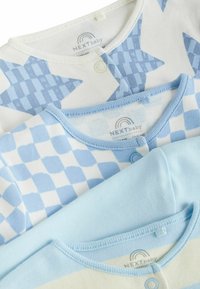 Tre babybodysuits i pastellblå nyanser: en med stjärnmönster, en med rutigt mönster och en i ensligt ljust blå.