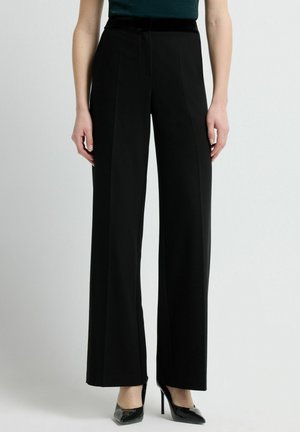 Zwarte wijde broek met een gladde textuur, voorzien van een fluwelen tailleband. Getailleerde pasvorm met voorplooien en een scherpe afwerking.