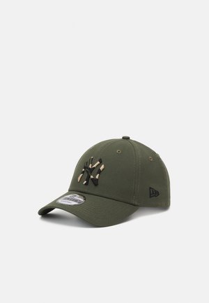 Khaki green baseball cap with a curved brim, featuring a black and tan embroidered logo on the front and a small black logo on the side.