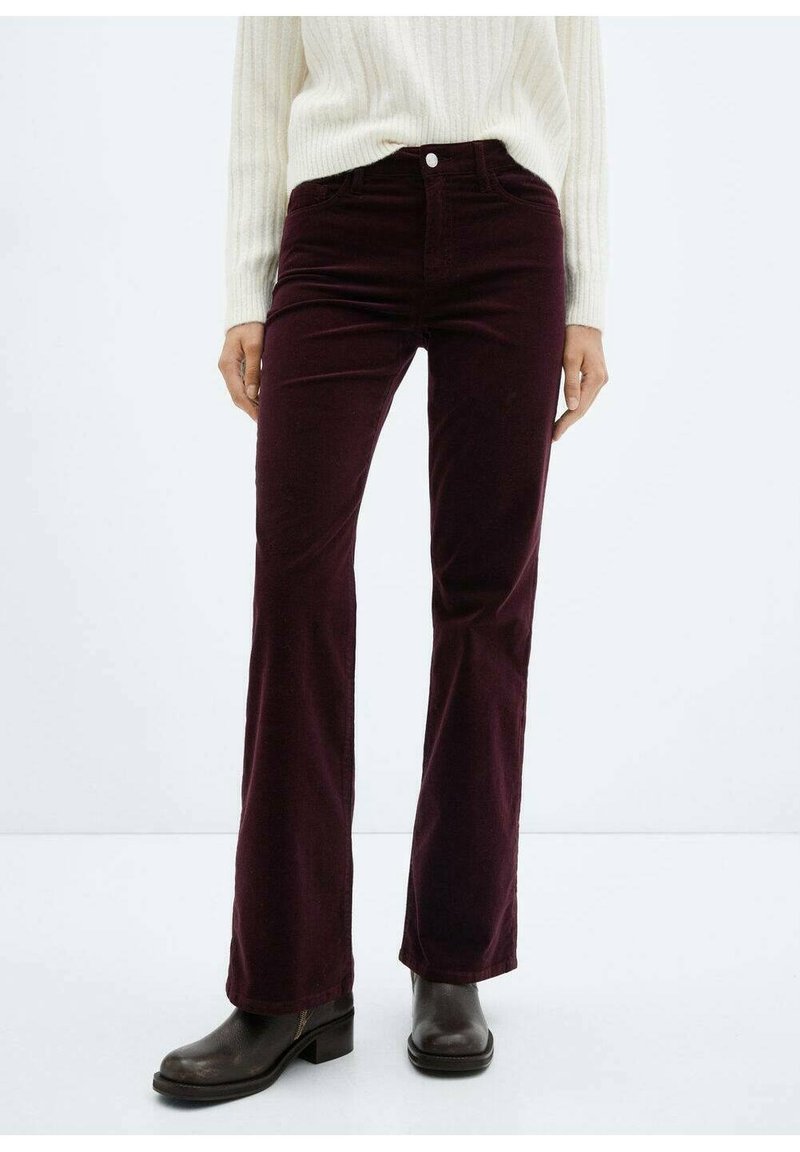 Pantalon en velours côtelé bordeaux à taille évasée avec une texture lisse et un design à cinq poches, doté d'un bouton et d'une fermeture zippée à l'avant.