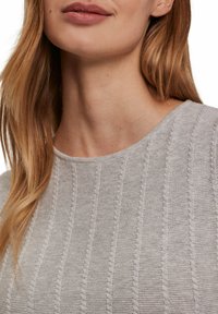 Jasnoszary, dziany top z teksturowym wzorem w pionowe linie oraz okrągłym dekoltem. Gładki materiał z subtelnymi detalami.