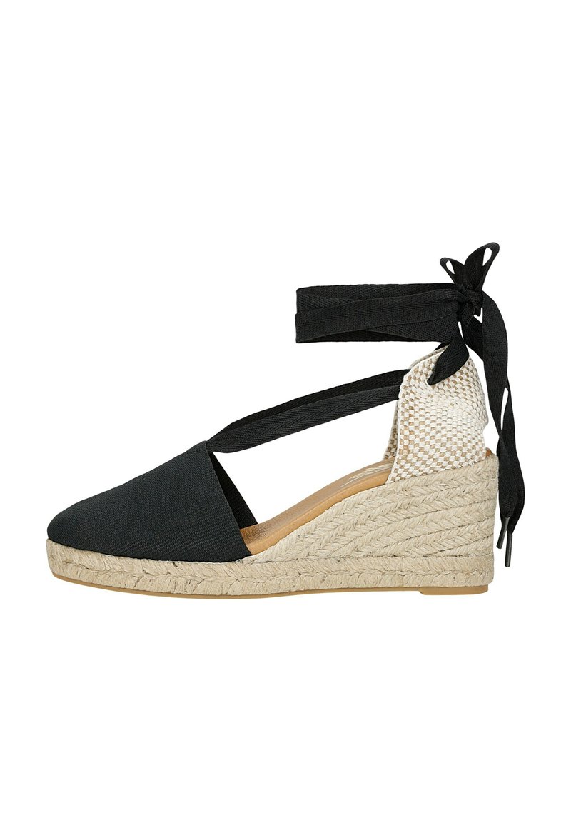 Black espadrille wedge sandal with textile upper and woven jute midsole. Features ankle straps and contrasting textured heel.