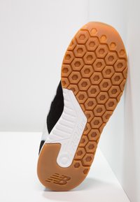 Sole di scarpa sportiva in bianco e nero con una trama di grip esagonale, caratterizzata da un leggero schiuma REVlite e un resistente suola in gomma.