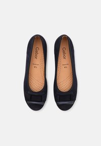 Pantofole ballerine in suede blu navy con punta arrotondata, piccolo fiocco decorativo sulla parte anteriore e soletta perforata beige per la traspirabilità.