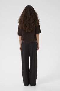 Un haut en tricot marron à manches courtes et un pantalon noir à jambes larges, offrant une coupe décontractée et une texture lisse, vus de dos sur un fond blanc.