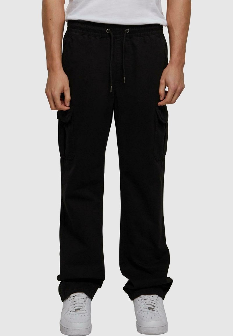 Pantalon cargo noir avec taille à cordon de serrage, poches latérales et coupe décontractée. Fabriqué en mélange de coton doux, avec une texture lisse.
