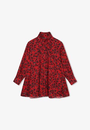 Blouse rouge avec des manches longues, un col montant et un motif floral noir et blanc. Présente des plis sur le devant pour plus de texture.