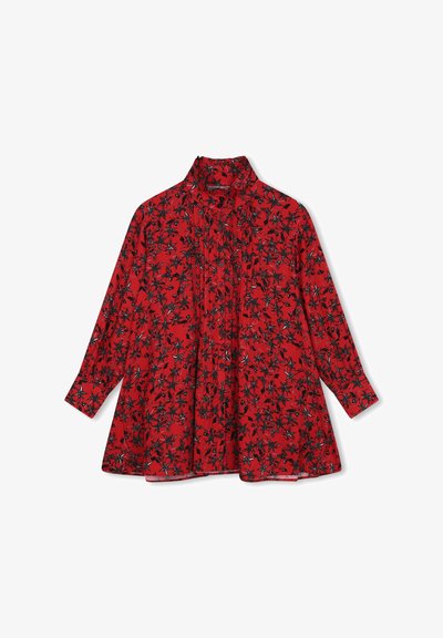 Blouse rouge avec des manches longues, un col montant et un motif floral noir et blanc. Présente des plis sur le devant pour plus de texture.