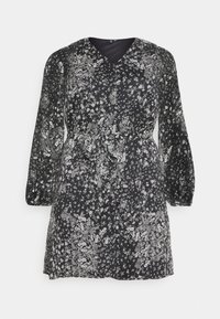 Vestido negro de flores con mangas largas, escote en V y cintura con lazo. Presenta un patrón floral blanco, tejido liviano y un corte holgado.