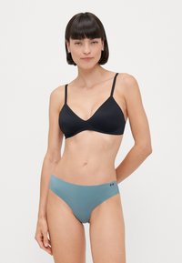 Black soft-cup bra featuring adjustable straps. Paired with light blue seamless bikini bottoms with subtle branding on the side.